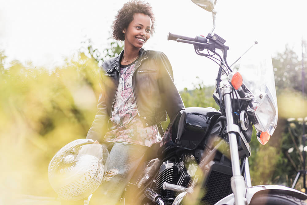 4 PT treatment methods for those with a motorcycle injury smiling young woman with her motorcycle 2023 11 27 05 17 17 utc 4 PT treatment methods for those with a motorcycle injury